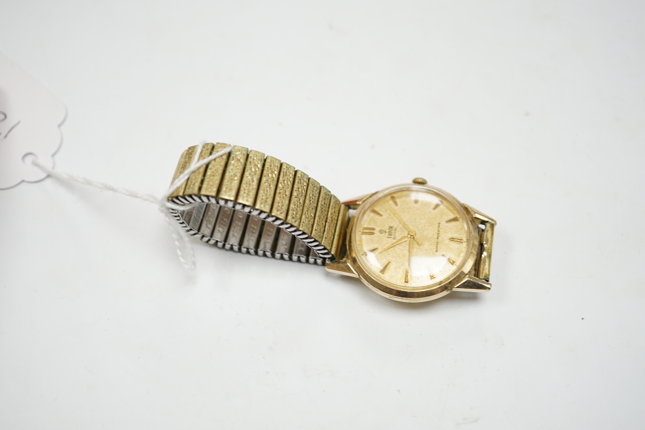 A gentleman's yellow metal Tudor Royal manual wind wrist watch, with baton numerals, on an associated flexible strap, with Tudor box.
